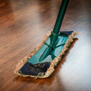 A detailed view of a mop cleaning a wooden floor, showing texture and pattern.